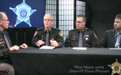 two sheriff officials shaking hands at table