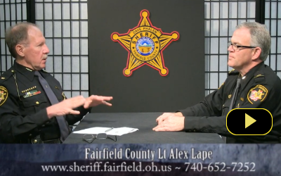 two sheriff officials shaking hands at table