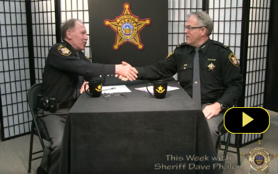 two sheriff officials shaking hands at table